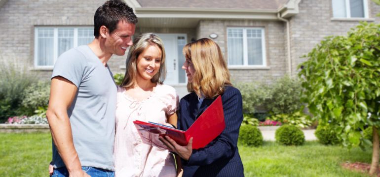 Real Estate agent woman near new house. Home for "Coming Soon" for sale concept.