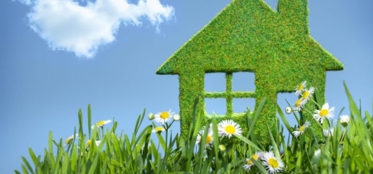 Green house built from grass against blue sky to represent concept of green building.