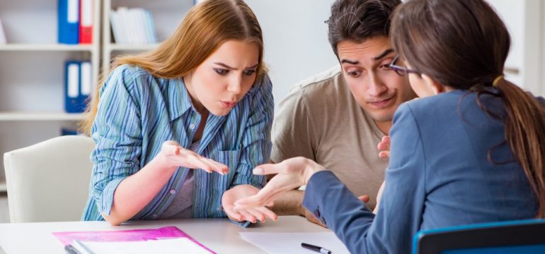 Young family disappointed by mortgage application denial at brokers office.