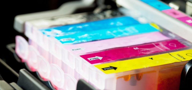 Color printer ink cartridges lined up in printer carriage.