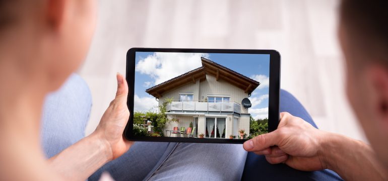 Close-up of millennials looking at a new home on an iPad.