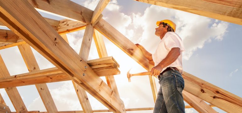 Homebuilder working on framing a roof for a new construction home.