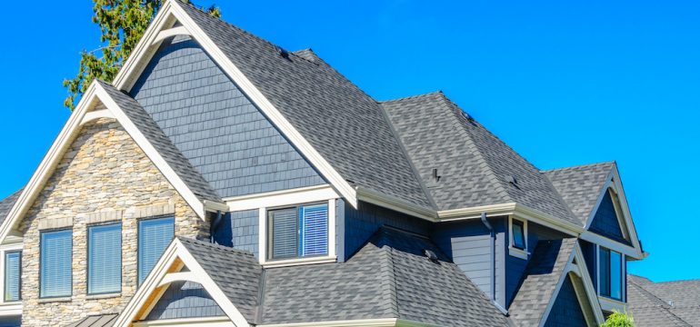 The roof of the house with nice windows against a blue sky.