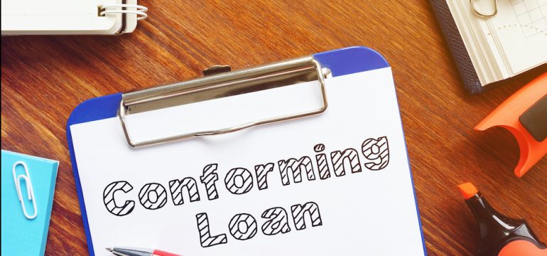 Conforming loan is shown on the conceptual business photo of a clip board with a document and pencil on a desk.