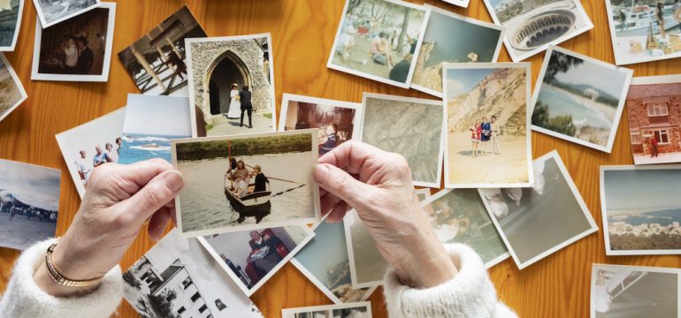 Top view of a senior caucasian woman sorting old photos. A task on her February to-do list.