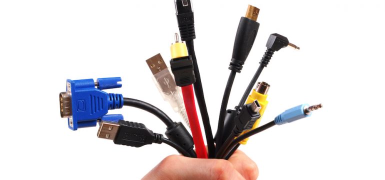 A bunch of electronic cords bunched in a person's fist.