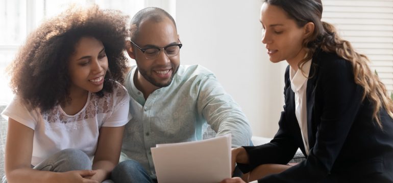 Couple at meeting with a REALTOR discussing contract terms.