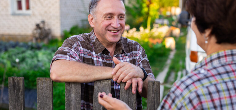 Airbnb hosting neighbors. A middle-aged man and his neighbor chatting near the fence between homes.