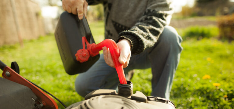 Gentleman adding fuel stabilizer to his lawn mower engine.
